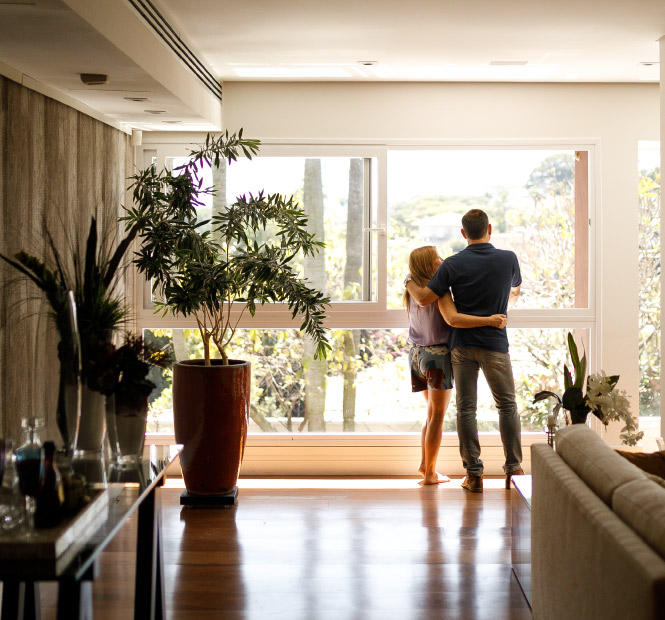 Mature couple looking out the living room windows.