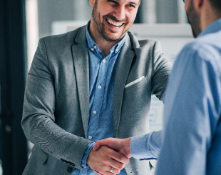 Happy business men shaking hands.