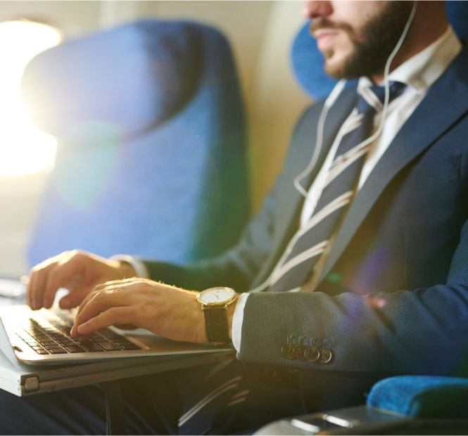 Business man working on a computer in an airplane.