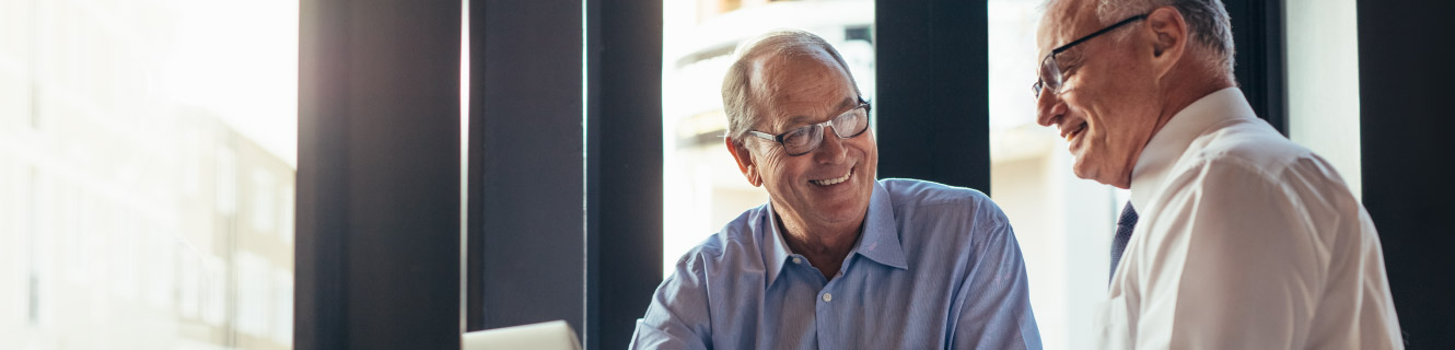 Two mature business men enjoy conversation.