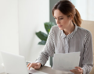 Business woman entering numbers into her computer.