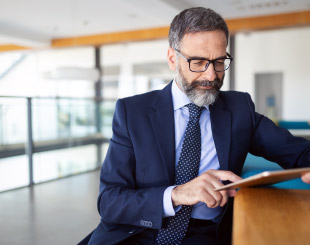 Business man working on tablet in a business lobby.